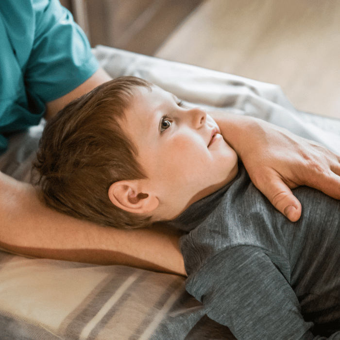 un enfant en train de se faire masser par une ostéopathe à Thiais