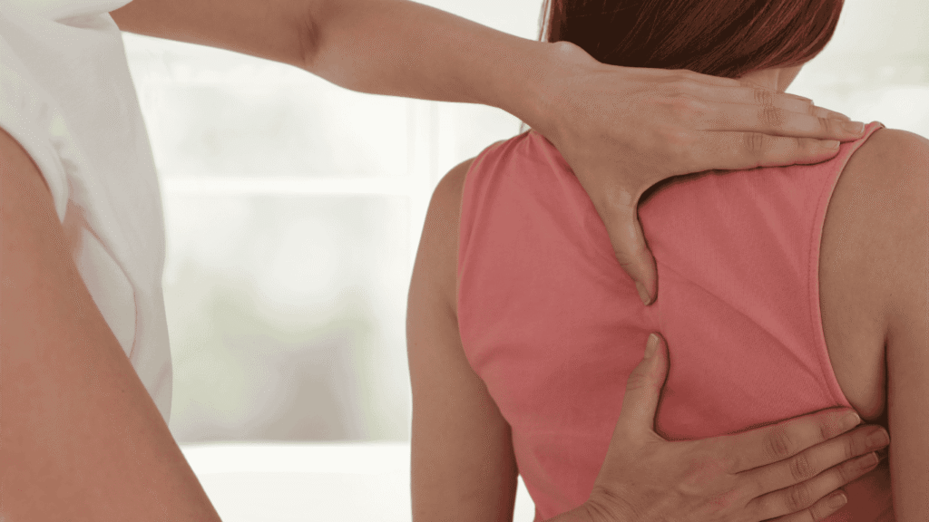 Séance d’ostéopathie dorsale à Saint‑Martory : manipulation douce du haut du dos d’une patiente par une ostéopathe